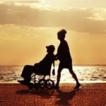 woman pushing man on wheelchair