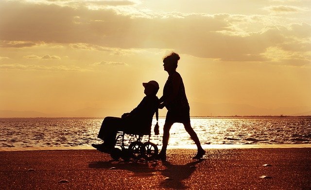 woman pushing man on wheelchair